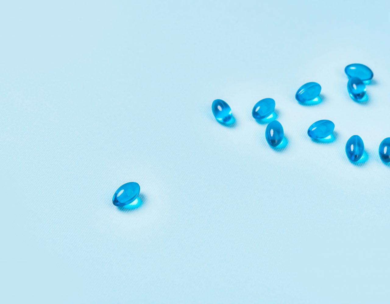 Pile of softgel blue capsule pills